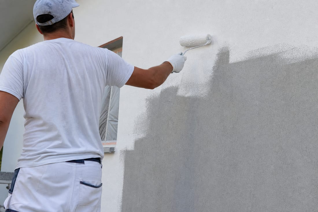 Exemple : peintre au rouleau sur une façade, vu de dos